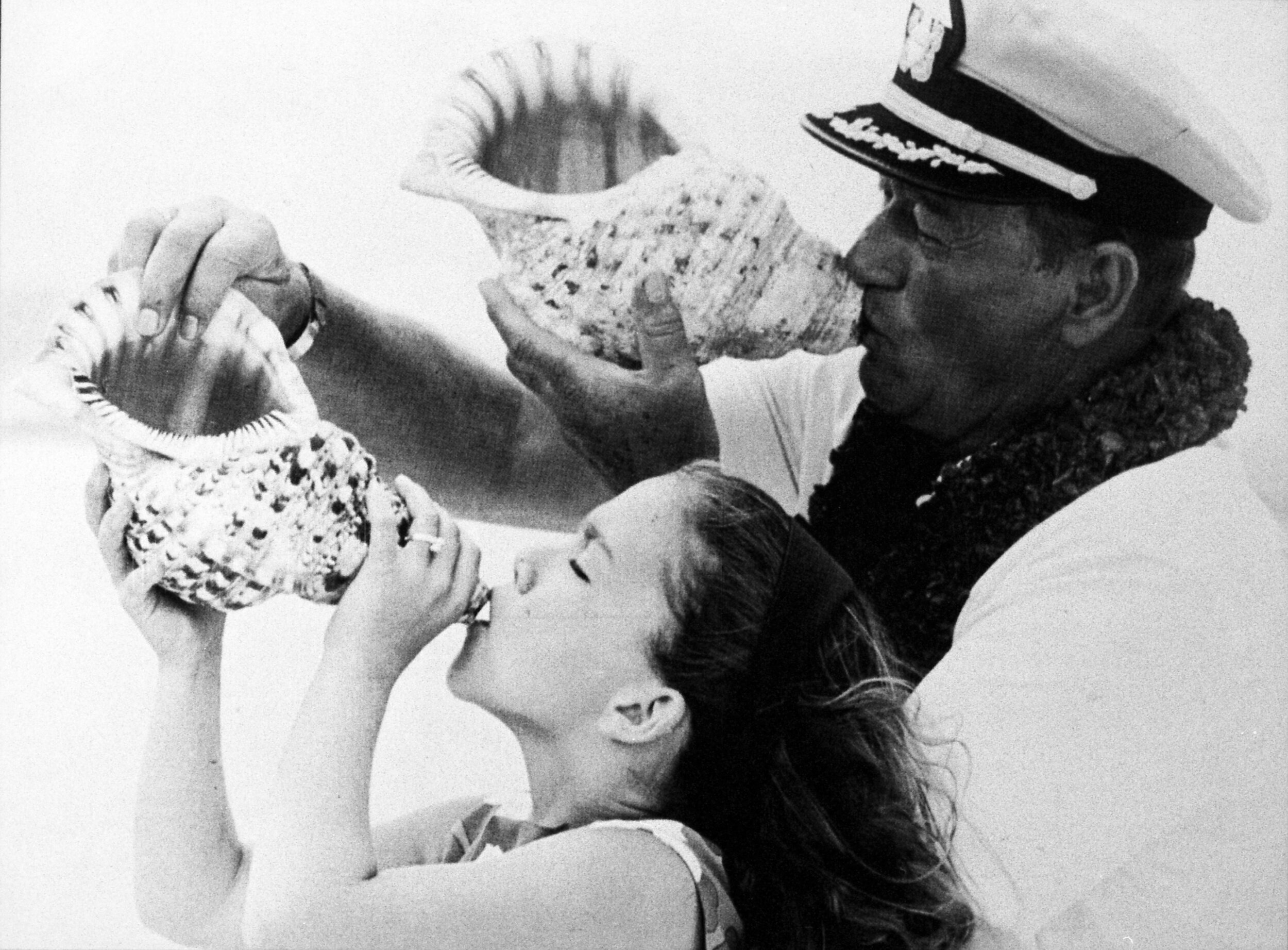 Aissa and her dad making music with conch shells.