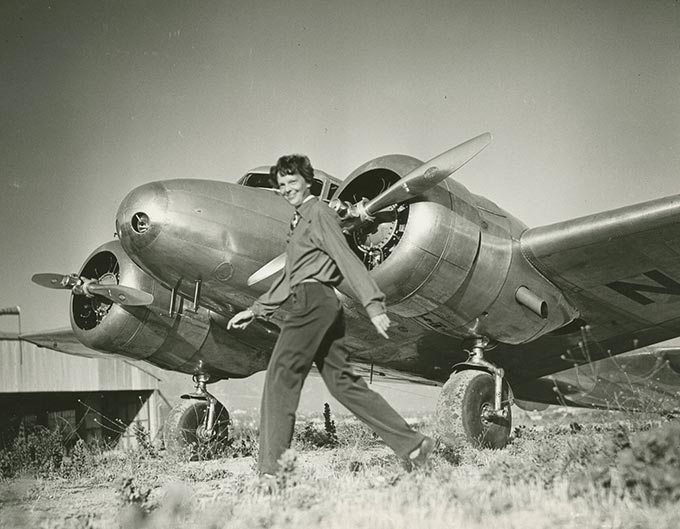 Amelia Earhart walking in front of her Lockheed Electra 10-E