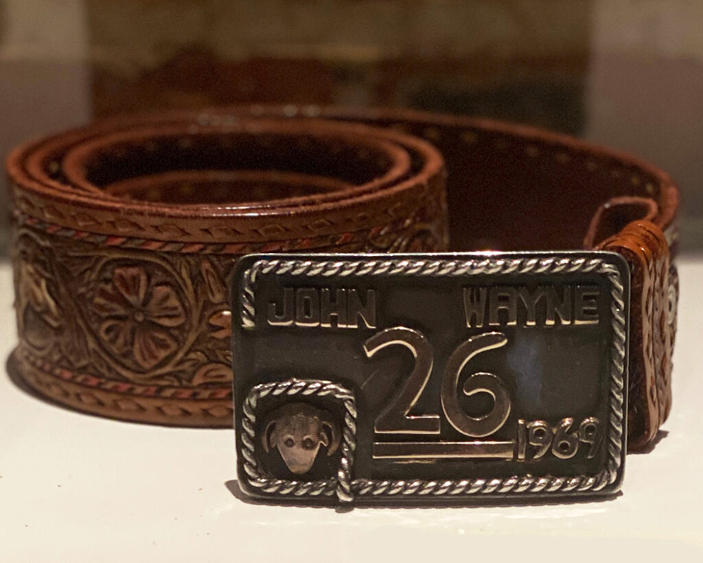 Close-up of John Wayne’s sterling 26 Bar Ranch buckle mounted on a tooled Sam Sisco belt, gifted by Ronald and Nancy Reagan in 1976.
