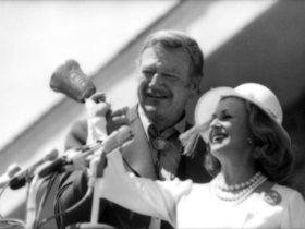 John Wayne and Marylou Whitney take part in Cody’s “Let Freedom Ring” ceremony on July 4, 1976, celebrating America’s Bicentennial. Wayne rang one of four commemorative hand bells cast from material left over from repairs to the original Liberty Bell, marking one of the day’s most symbolic moments. (Courtesy of the Buffalo Bill Center of the West, Cody, Wyoming, USA; McCracken Research Library)